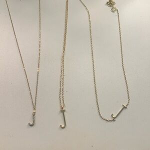 Initial J necklaces in gold.